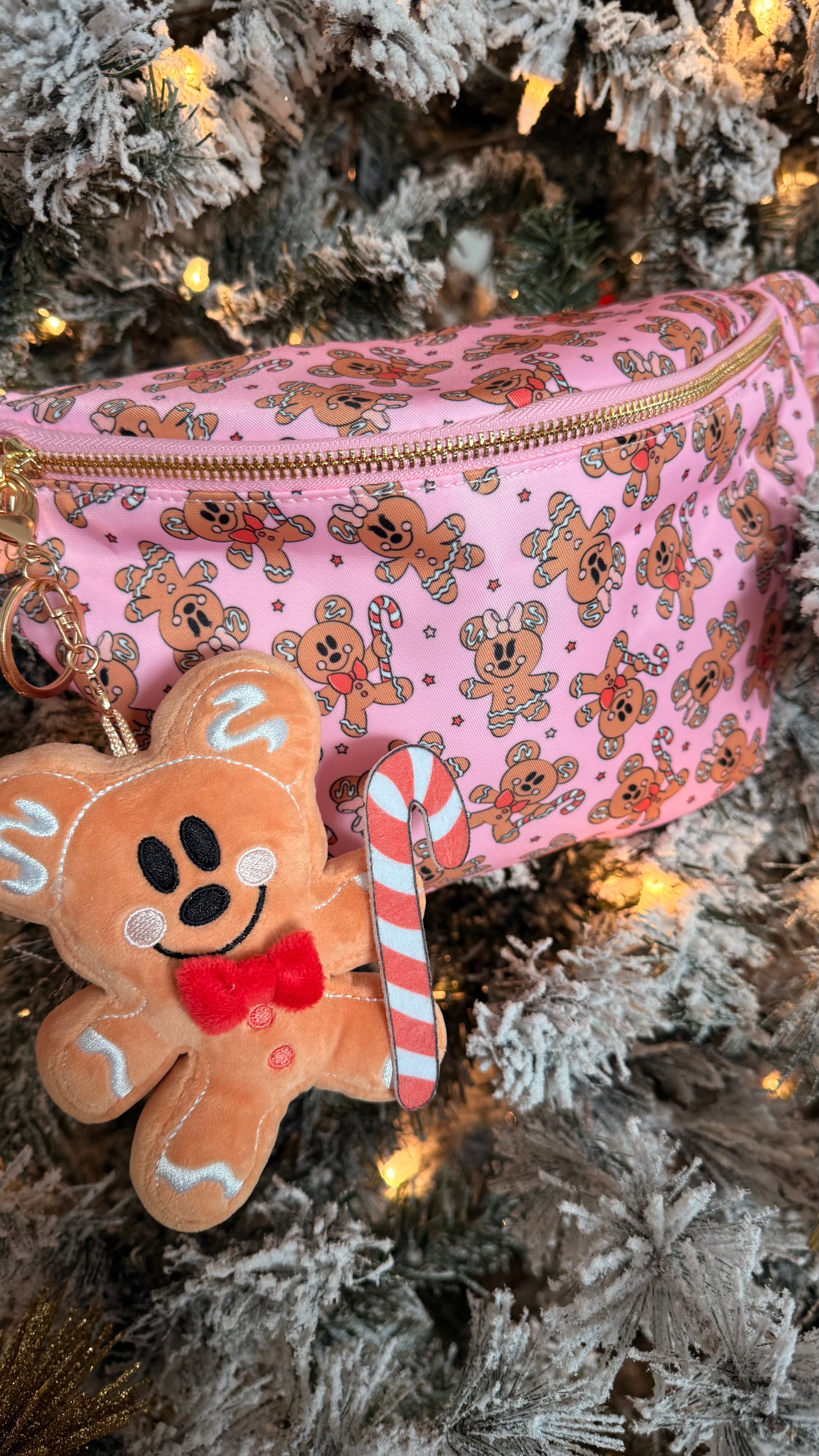 Pink pouch with gingerbread design and gingerbread man keychain on a Christmas tree.