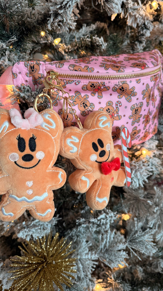 Gingerbread man-shaped keychains on a pink pouch with a Christmas tree background