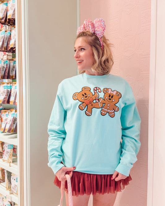 Person wearing a light blue sweatshirt with teddy bear graphics, pink bunny ears, and a red skirt in a store.